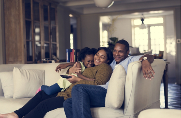 Family snuggling on the couch in their home