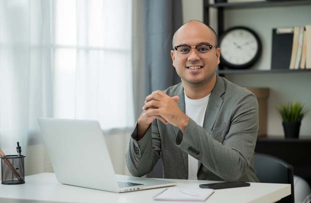 Young male customer service rep from Selective wearing glasses and smiling
