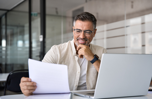 Middle-aged agent reviewing paperwork about the recent Selective personal insurance policy he quoted.